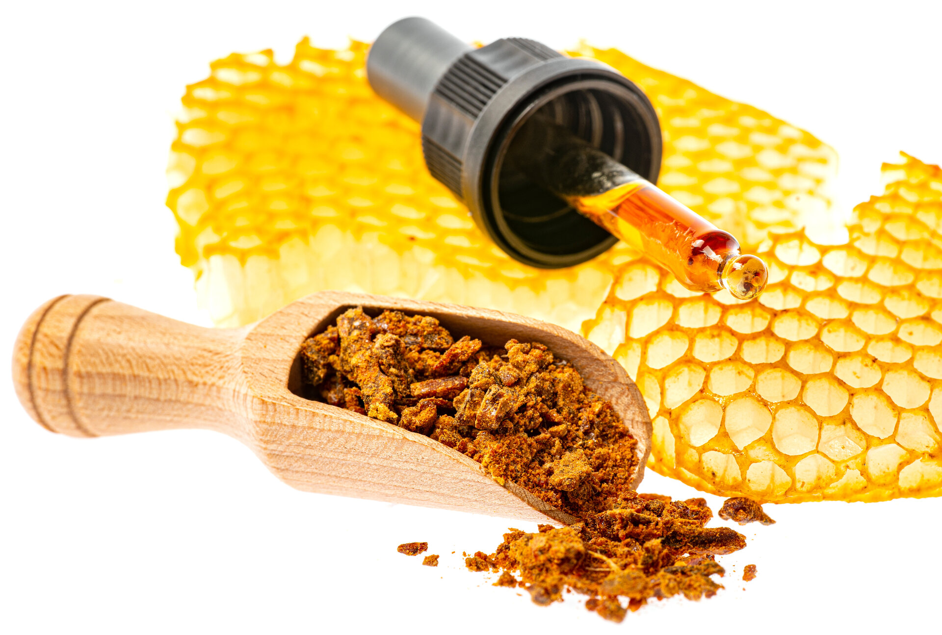 Propolis-Tinktur und ein Holzlöffel mit Propolis-Extrakt