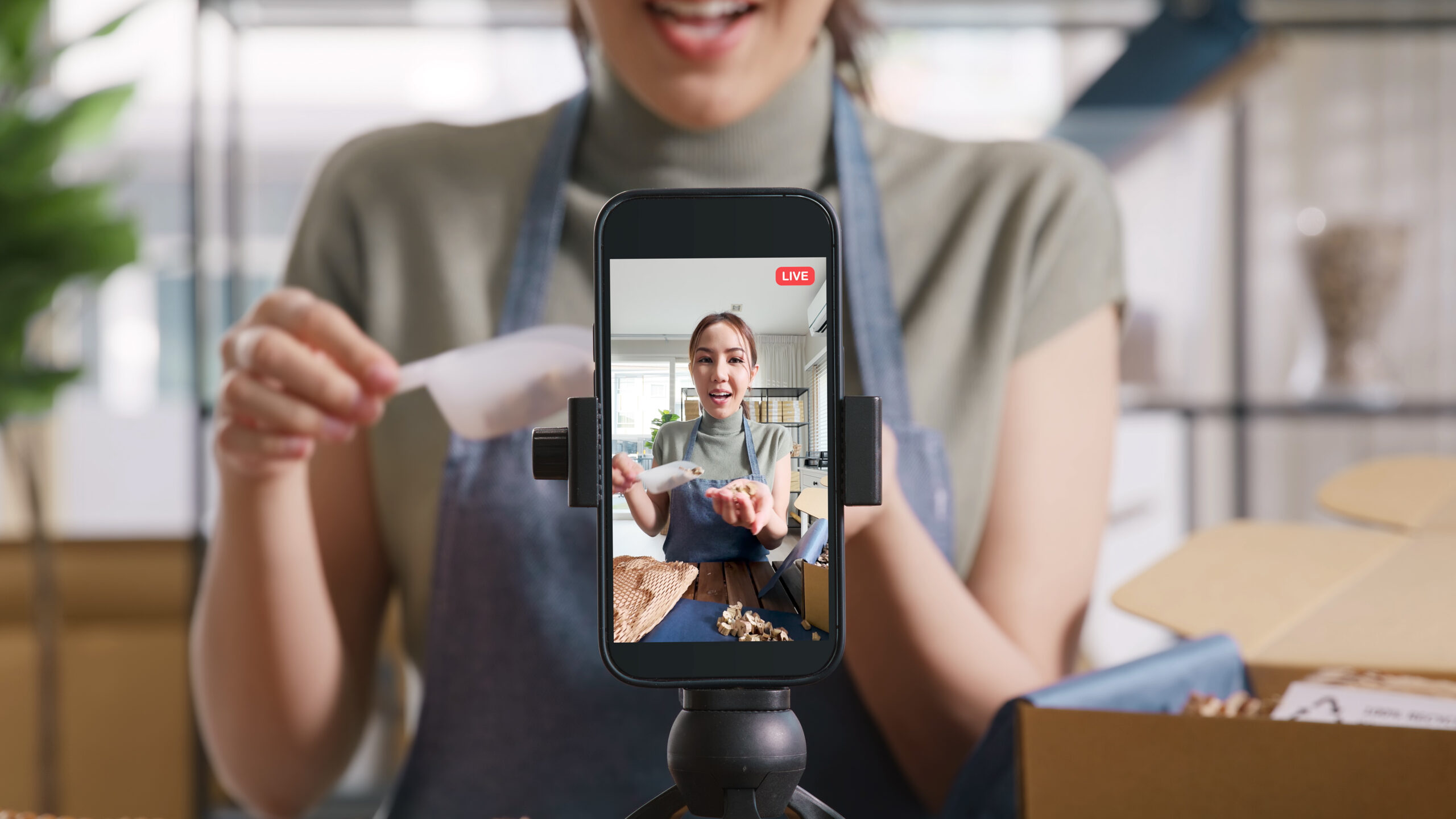 Live-Stream-Gespräch am Telefon, das eine umweltschonende, plastikfreie Verpackungsbox zeigt. Asiatische Menschen junge Frau nehmen Video auf Tiktok IG Reel Instagram Shop Happy Side Hustle auf.