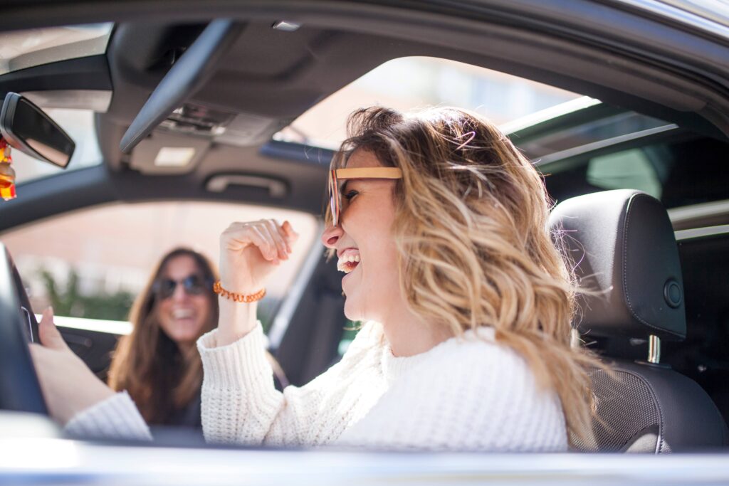 Zwei Frauen lachen und genießen die Zeit während des Wab Kurses in Winterthur, aufgenommen im Auto während einer Fahrpause