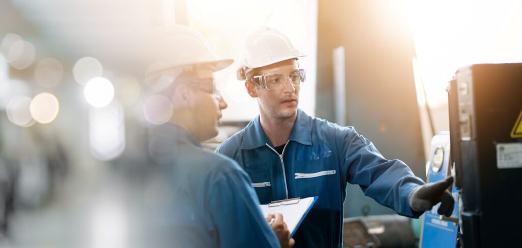 Zwei Männer bedienen Maschine einer Fabrik