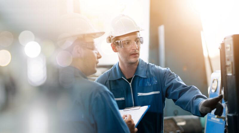 Zwei Männer bedienen Maschine einer Fabrik