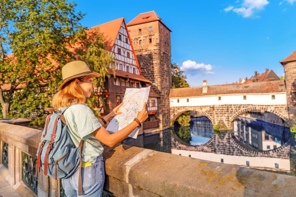 Frau mit Karte erkundet die Nürnberger Altstadt. Nützliche Hinweise für Reisende, inklusive Informationen zum Parken Flughafen Nürnberg.