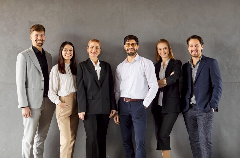 Business-Team steht gemeinsam fuer betriebliche Gesundheitsfoerderung und gesunde Arbeitskultur