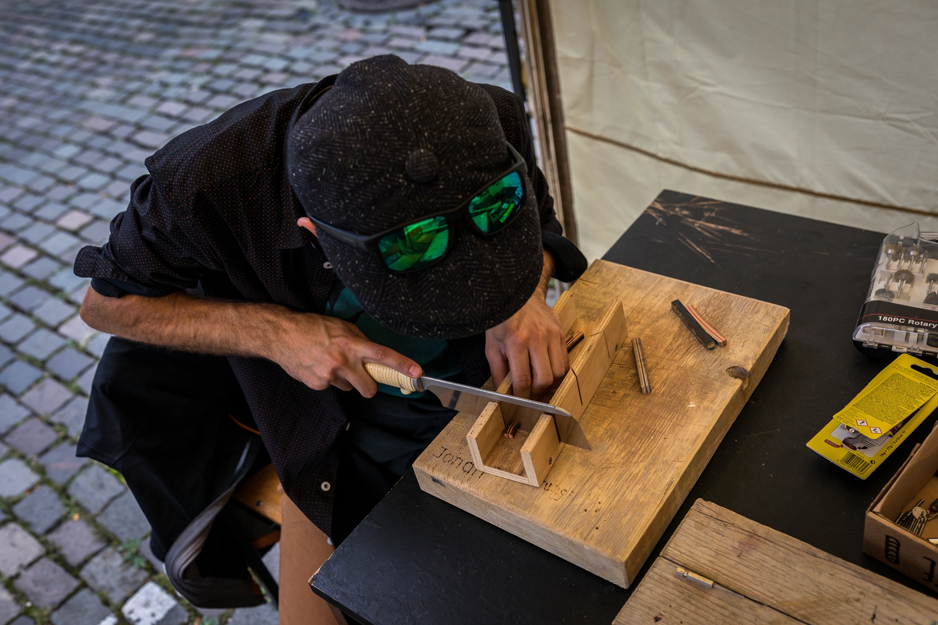 Person sägt Holz in Werkstattumgebung | Buttonmaschine