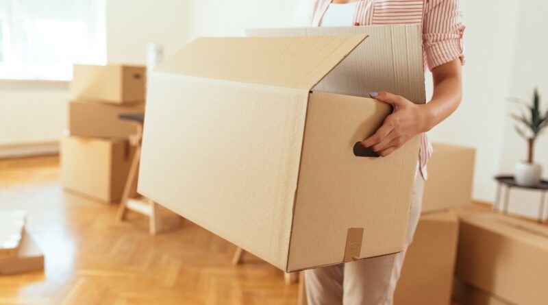 Frau mit Karton in leerer Wohnung | Wohnungsauflösung Neuss