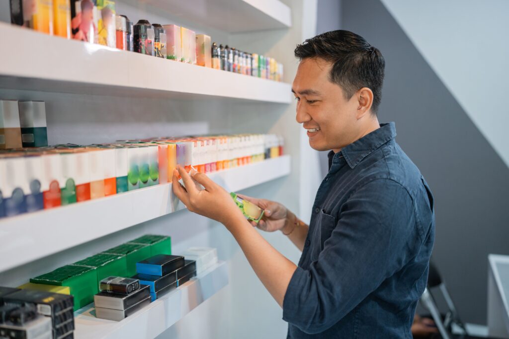 Mann prüft Elfbar Liquids im Fachhandel und vergleicht verschiedene Geschmacksrichtungen im Regal