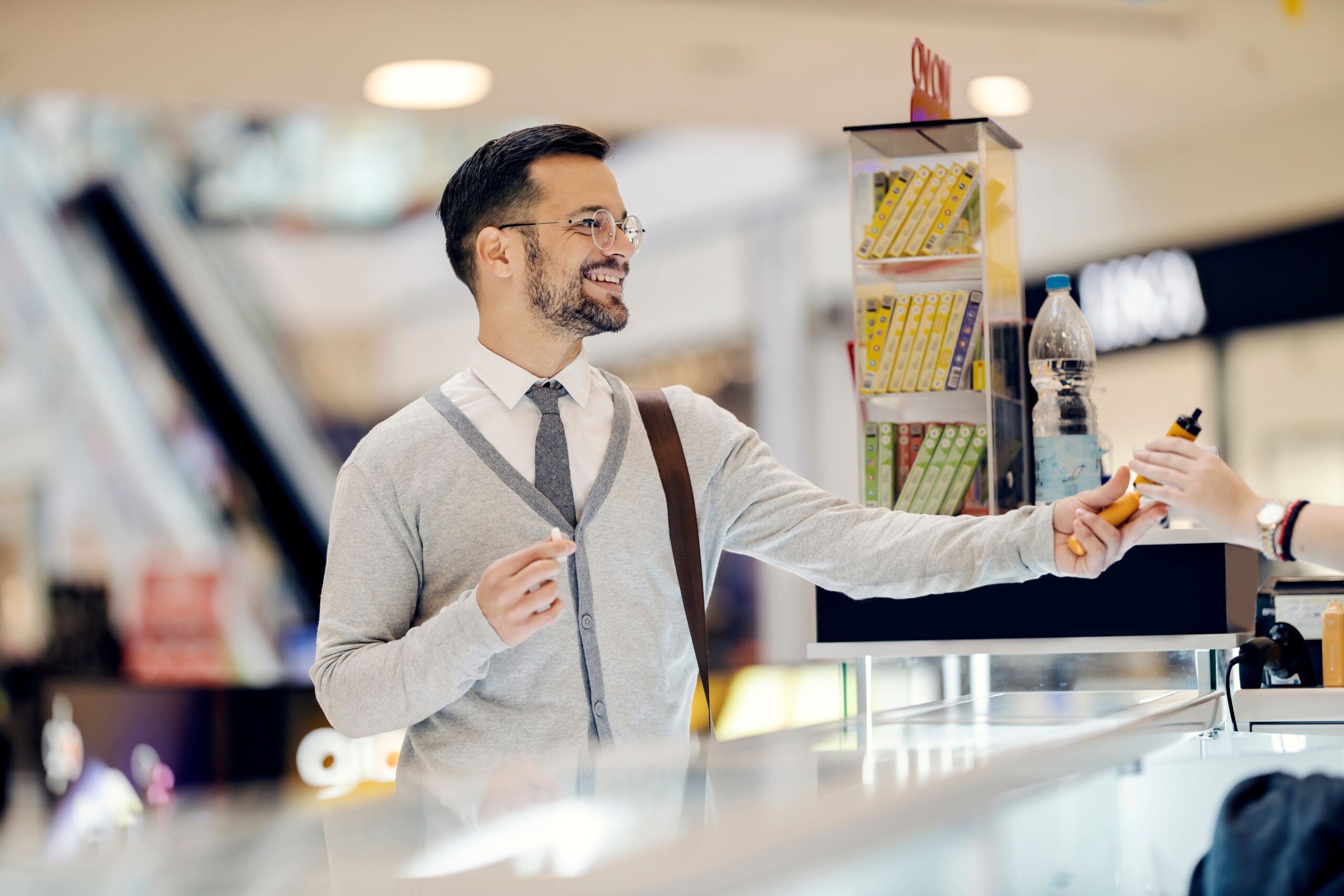 Mann hält Elfbar Liquid nach der Auswahl im Shop in der Hand und lächelt zufrieden
