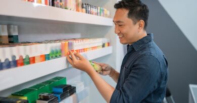 Mann prüft Elfbar Liquids im Fachhandel und vergleicht verschiedene Geschmacksrichtungen im Regal