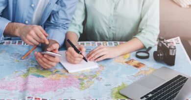 Paar plant Reise mit Weltkarte und Laptop | Emirates Business Class