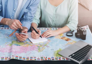 Paar plant Reise mit Weltkarte und Laptop | Emirates Business Class